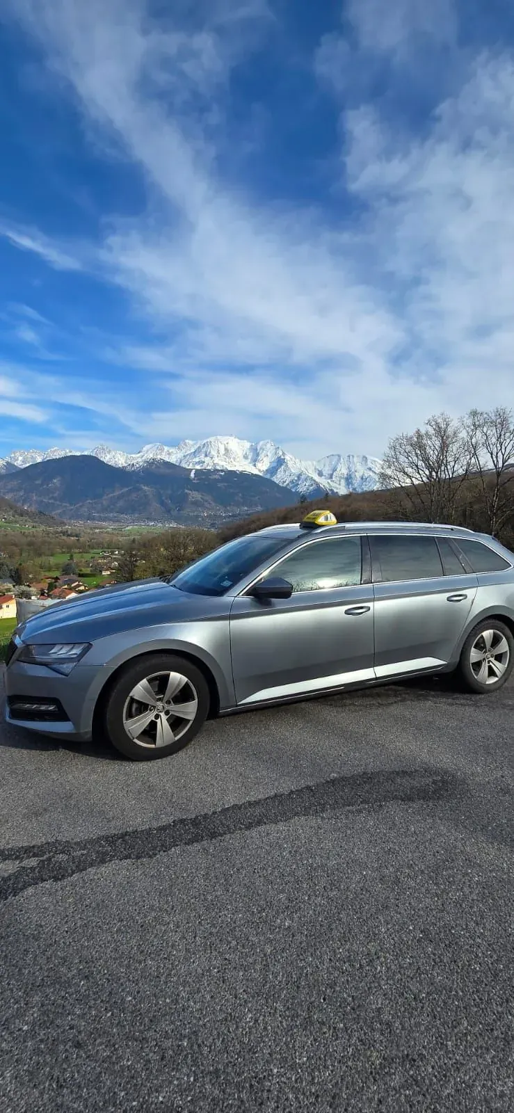 Onway Taxi Gaillard’s Skoda Superb estate, side view, in front of snow-capped peaks